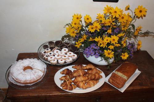 a table topped with plates of food and flowers at B&B Ca' Erminia in Chiesa in Valmalenco