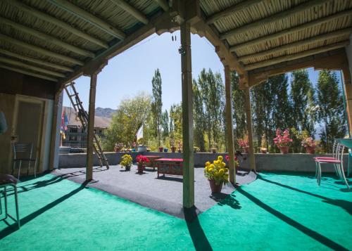 una piscina en un patio con una mesa y flores en The Morning Sky hotel, en Leh
