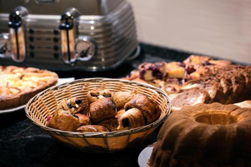 a table topped with a basket of pastries and pies at Hotel Praga 1 in Prague