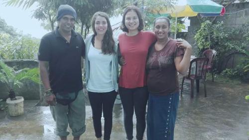 un gruppo di persone in piedi sotto la pioggia di J hostel kandy a Kandy