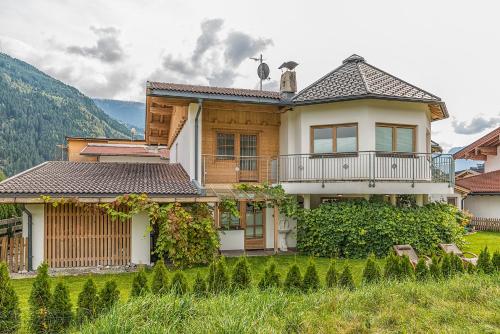 a house with a balcony on top of a yard at Sportchalet Zillertal in Uderns