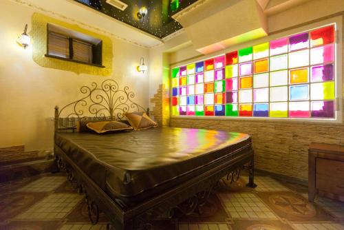 a bed in a room with a stained glass window at Salut Hotel Almaty in Almaty