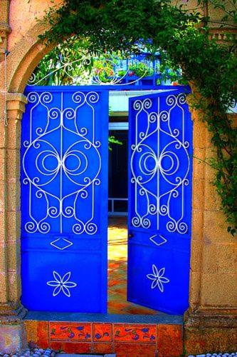 a blue door with a gate in a building at Hotel Kalithea in Kallithea Rhodes
