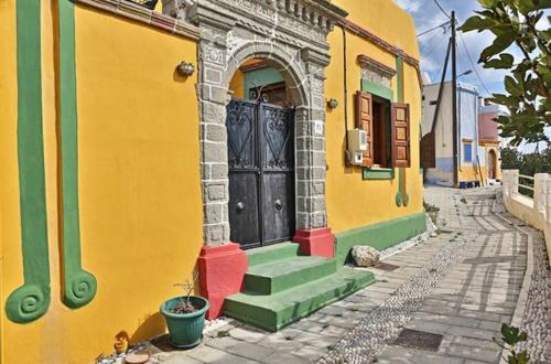 a yellow and green building with a door on a street at Hotel Kalithea in Kallithea Rhodes