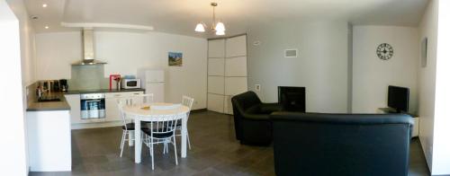 une cuisine et un salon avec une table et des chaises dans l'établissement En so de Bourdet, à Lourdes