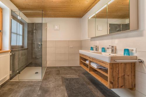 uma casa de banho com um lavatório e um chuveiro em Sportchalet Zillertal em Uderns