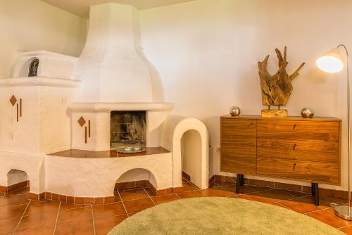 a living room with a fireplace and a dresser at Sportchalet Zillertal in Uderns