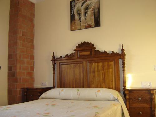 a bedroom with a bed with a wooden head board at Casa La Vega in El Bosque