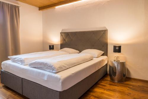 a large bed in a bedroom with two lamps at Sportchalet Zillertal in Uderns