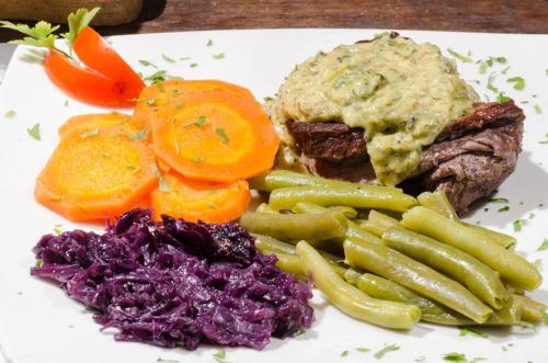 a plate of food with meat and vegetables on a table at Finca de la Vaca - Family House in Mera