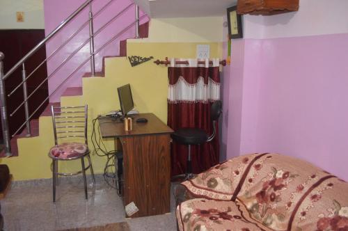 a living room with a desk and a staircase at Azure Family Paying Guest House in Varanasi