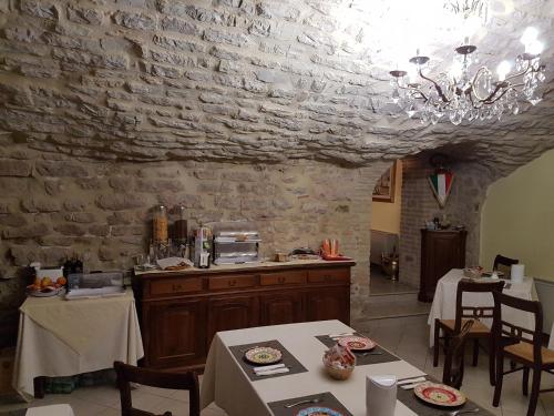 a kitchen with a table and a stone wall at Hotel Ponte San Vittorino in Assisi