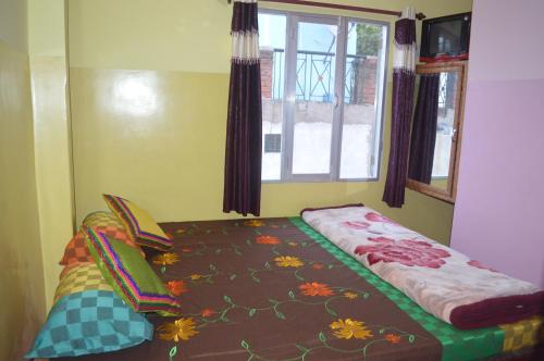 a small bed in a room with a window at Azure Family Paying Guest House in Varanasi