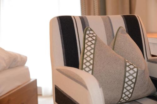 a couch with a bunch of pillows on it at "Quality Hosts Arlberg Hotel Garni Mössmer" in Sankt Anton am Arlberg