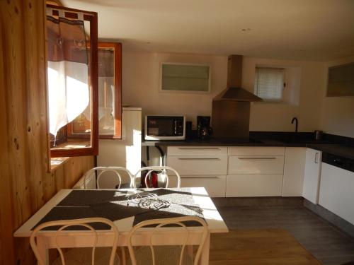 une cuisine avec une table et des chaises dans l'établissement Les Clarines, à Saint-Gervais-les-Bains