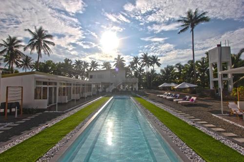einen Pool in einem Resort mit Palmen in der Unterkunft L'Sirene Boutique Resort in Baler