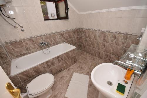 een badkamer met een toilet, een wastafel en een bad bij Vila Loza in Herceg-Novi