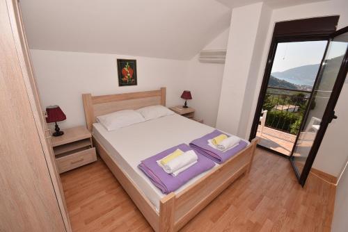 een slaapkamer met een bed en een balkon bij Vila Loza in Herceg-Novi