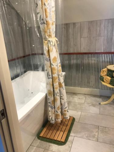 Un baño con cortina de ducha y bañera. en Hermann Barn House, en Hermann