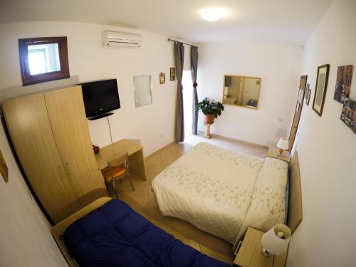 a small bedroom with a bed and a desk at Le Cascatelle in Cerveteri
