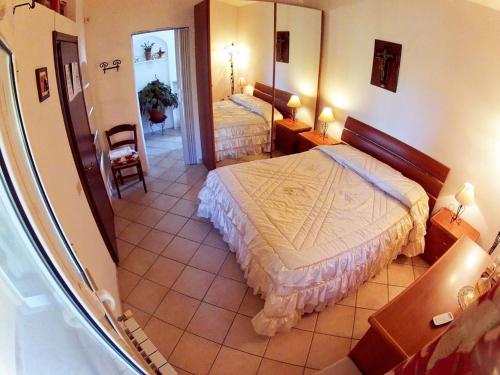 a bedroom with a large bed and a mirror at Le Cascatelle in Cerveteri