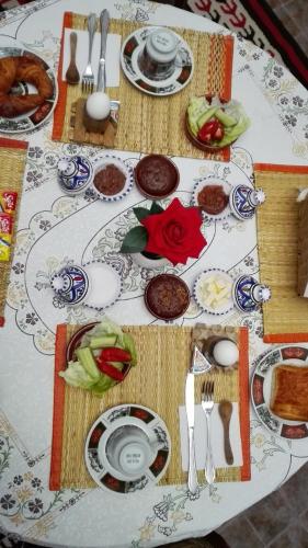 a table with plates and utensils on it at Dar El Kasba Riad Guest House in Bizerte