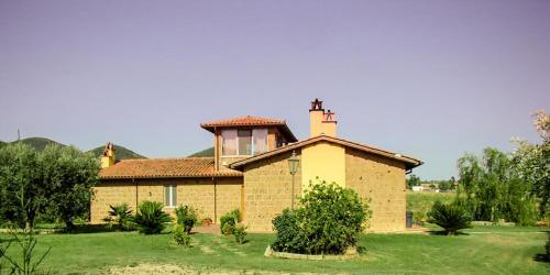 a brick house with a cross on top of it at Le Cascatelle in Cerveteri