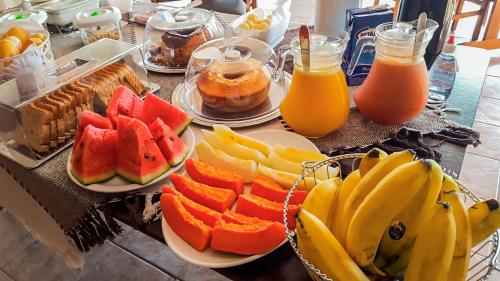 een tafel met borden fruit en sap bij Pousada Brasil Cumbuco in Cumbuco