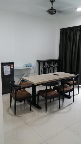 a large wooden table with two benches and chairs at The Aliff Residences in Johor Bahru