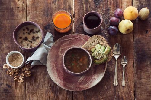 巴涅雷斯德马里奥拉MasQi, The Energy House的一张木桌,上面放着一盘食物,配以汤和面包