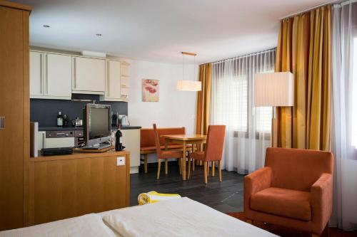 a hotel room with a kitchen and a dining room at Chasa Miramont in Samnaun