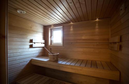 a small wooden sauna with a bucket in it at Soukolo Apartments in Äkäslompolo
