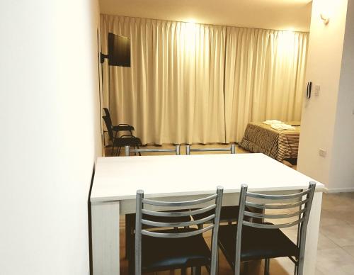 a room with a table and chairs and a bedroom at Apartamento La Plata in La Plata