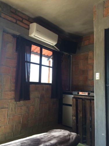 a kitchen with a brick wall and a window at Posada Don Jose in El Fuerte