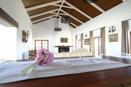 Una habitación con una cama con un jarrón de flores sobre una mesa en Casas de Alisné, en Almodóvar del Río