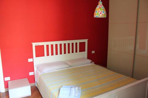 - une chambre avec un mur rouge et un lit blanc dans l'établissement Youhome Millelire Apartment, à Milan