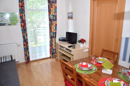 a dining room with a table and a television at Apartmán Rokytka 205 in Rokytnice nad Jizerou