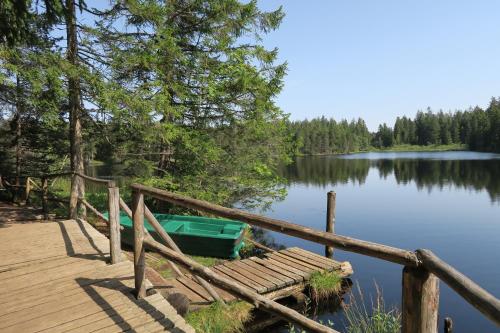 a boat sitting on a dock next to a lake at L'Union B&B - Chambres d'hôtes in Tramelan