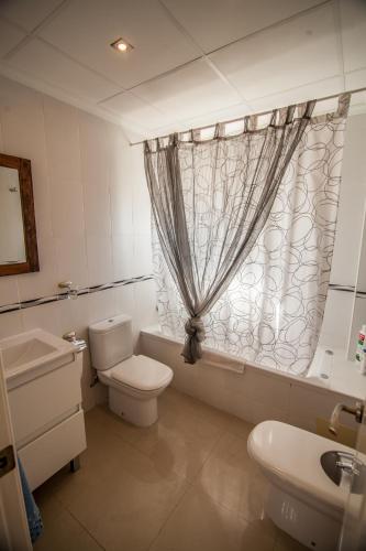 a bathroom with a toilet and a sink and a window at Villa Paradise Campello in El Campello