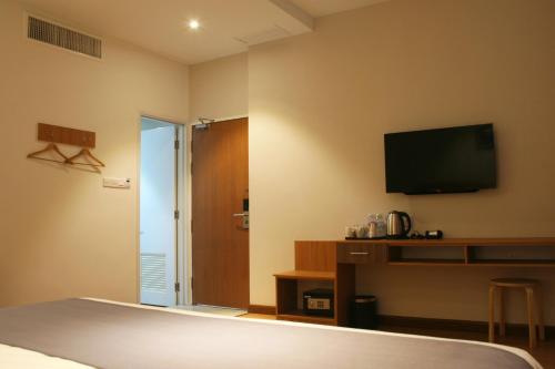 a hotel room with a bed and a flat screen tv at Ahyu Hotel in Kuala Lumpur