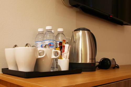 a counter with a coffee maker and water bottles on it at Ahyu Hotel in Kuala Lumpur