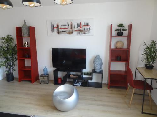 a living room with a television and a table with a chair at Appartement HEMINGWAY in Avignon