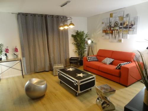 a living room with a red couch and a table at Appartement HEMINGWAY in Avignon