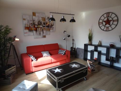 a living room with a red couch and a table at Appartement HEMINGWAY in Avignon