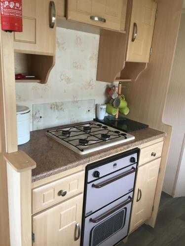 a kitchen with a stove and a counter top at 4 bedroom caravan ingoldmells skegness in Ingoldmells