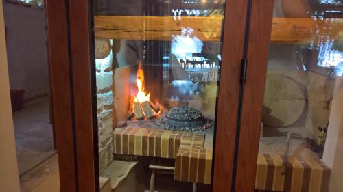 a fire in a glass door with a table with a fireplace at Apartment Anastazija in Omiš