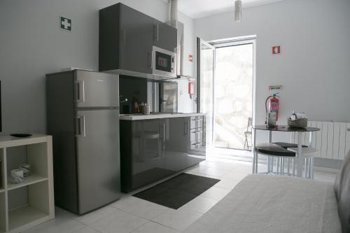 uma cozinha com um frigorífico, uma mesa e uma janela em Covelo Apartment no Porto
