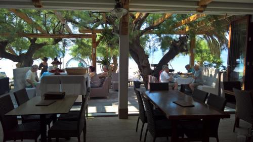 a restaurant with tables and chairs and people eating at Apartment Anastazija in Omiš