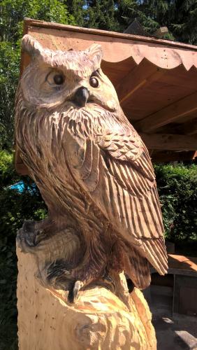a statue of an owl sitting on a stump at Penzion Pod Boubínem in Kubova Huť