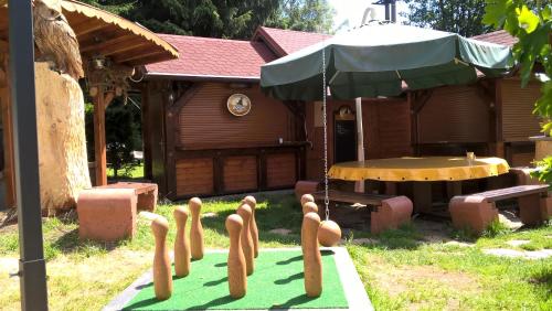 a garden with a table and an umbrella and someickets at Penzion Pod Boubínem in Kubova Huť
